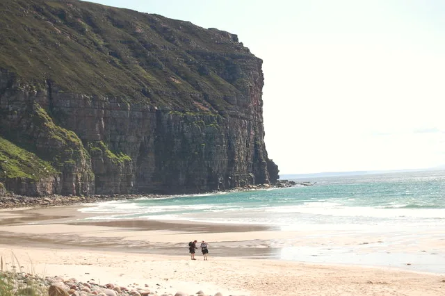 Rackwick Bay on Hoy, Orkney — pink-tinged sand and huge sea-smoothed boulders ringed by towering red-sandstone cliffs