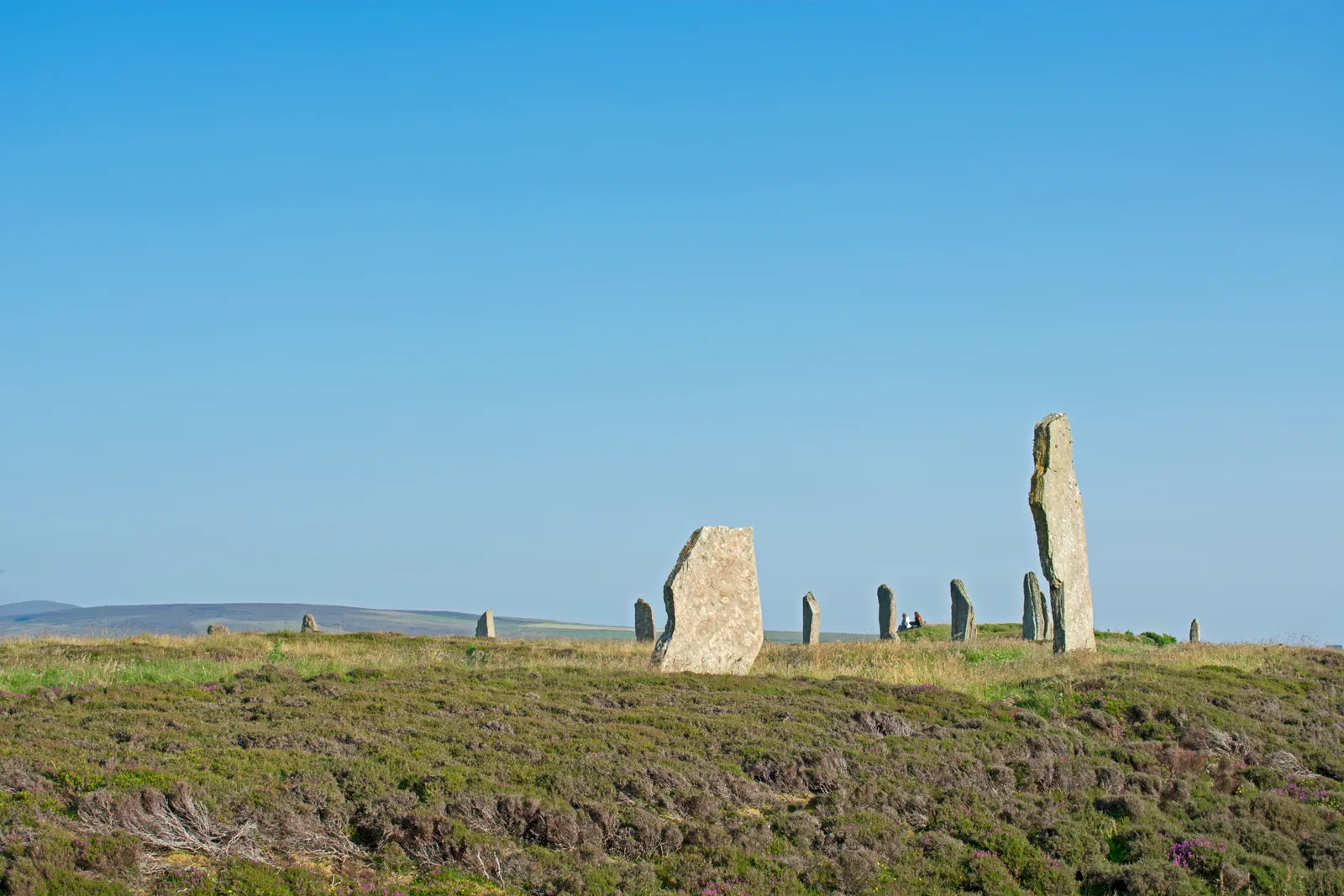 The Ring of Brodgar stone circle on a low heather ridge between two lochs in Orkney