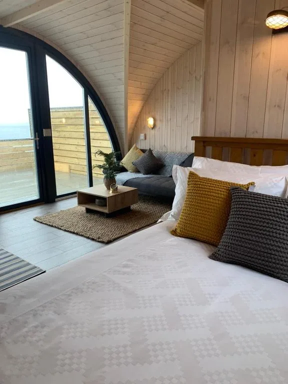 Orkney Lux Lodges Hamnavoe, a contemporary luxury villa above Stromness with floor-to-ceiling windows facing the Hamnavoe harbour and a private terrace hot tub overlooking the inner bay