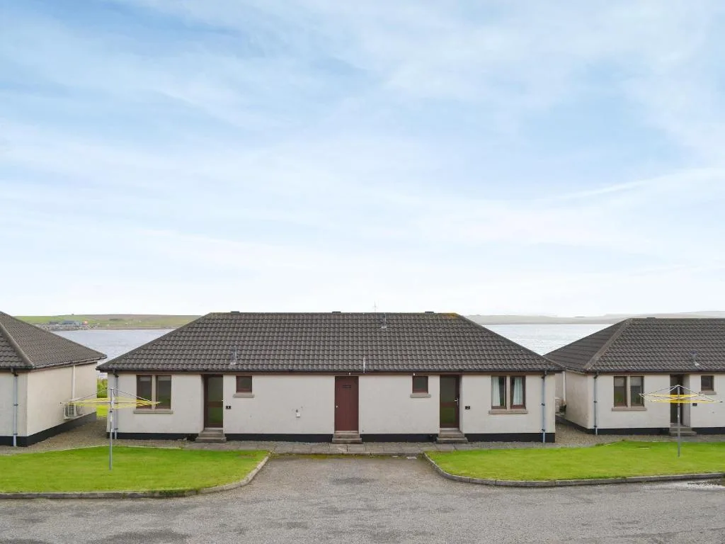 A Rockworks Chalet at St Marys in Holm, Orkney, with open patio doors from the dining area looking straight out over a broad expanse of open water