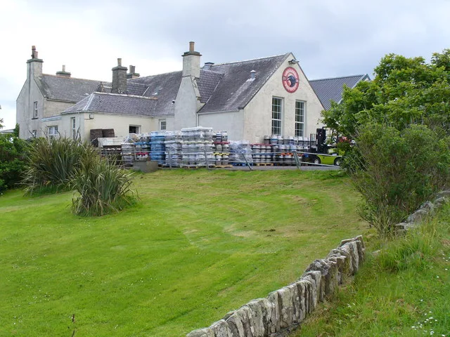 The Orkney Brewery at Quoyloo, Orkney — a converted Victorian schoolhouse with white-painted walls and a grey slate roof, set among green fields on the west Mainland