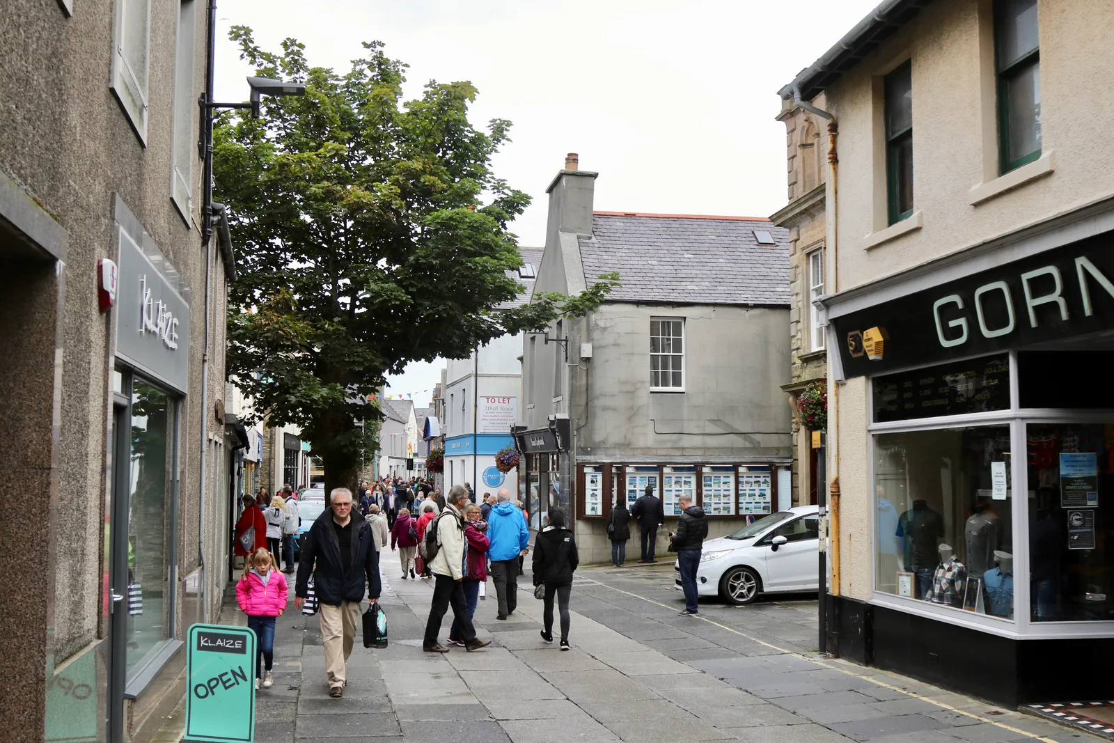 Albert Street, Kirkwall &mdash; a narrow flagstone-paved shopping street lined with independent shopfronts, busy with people on foot