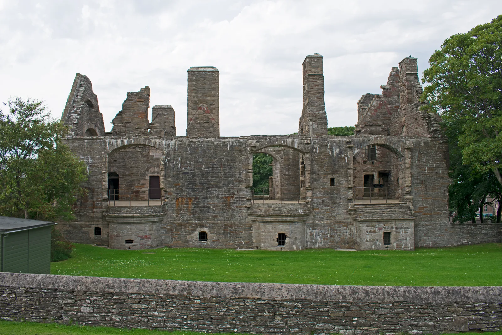 The roofless ruin of the Earl&rsquo;s Palace, Kirkwall, seen from the east &mdash; three storeys of grey flagstone with projecting bays and tall chimney stacks