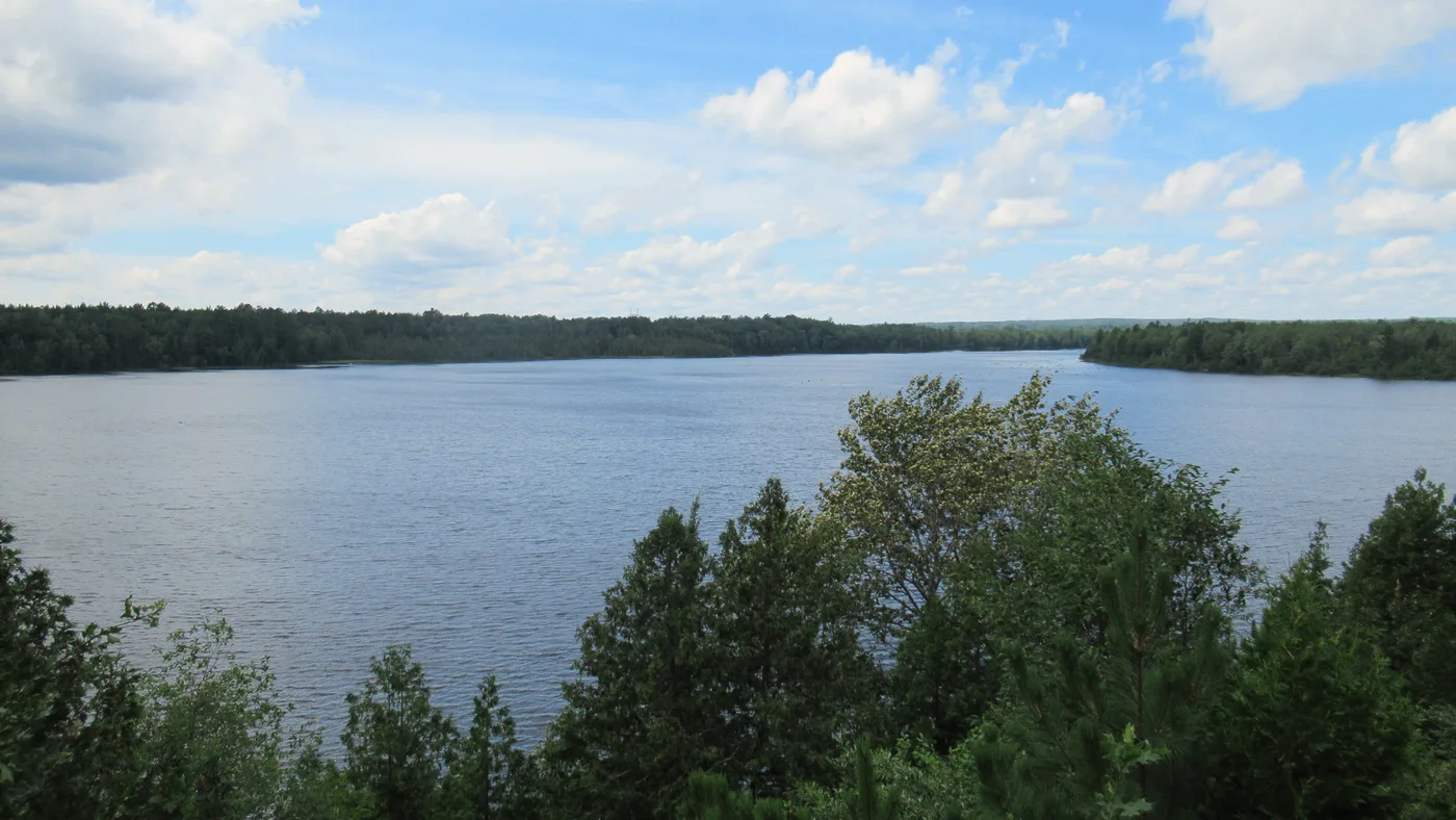 The calm open water of Mio Pond, the reservoir impounded by Mio Dam on the Au Sable River in Oscoda County, Michigan