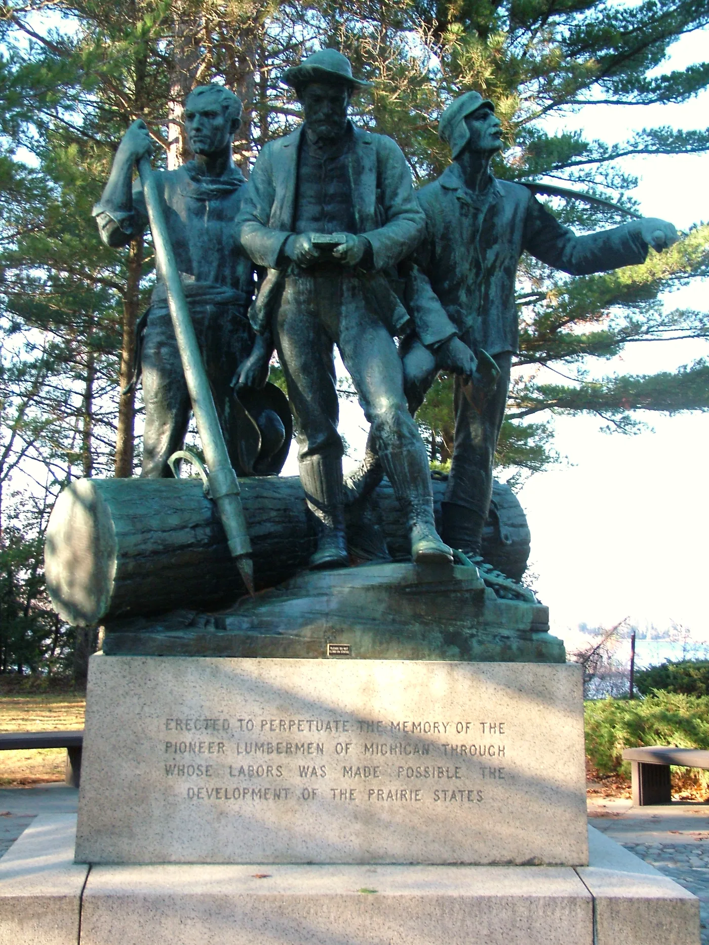 The bronze Lumberman's Monument, three logger figures around a log, overlooking the Au Sable River valley near Oscoda, Michigan