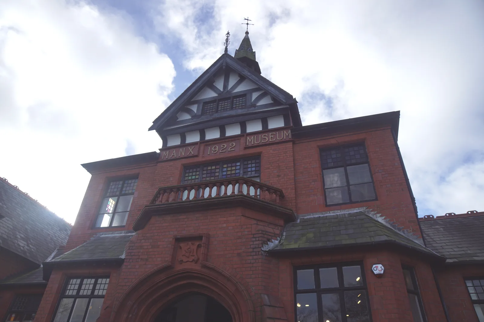 The red-brick front of the Manx Museum in Douglas, with MANX 1922 MUSEUM lettered above the original arched entrance