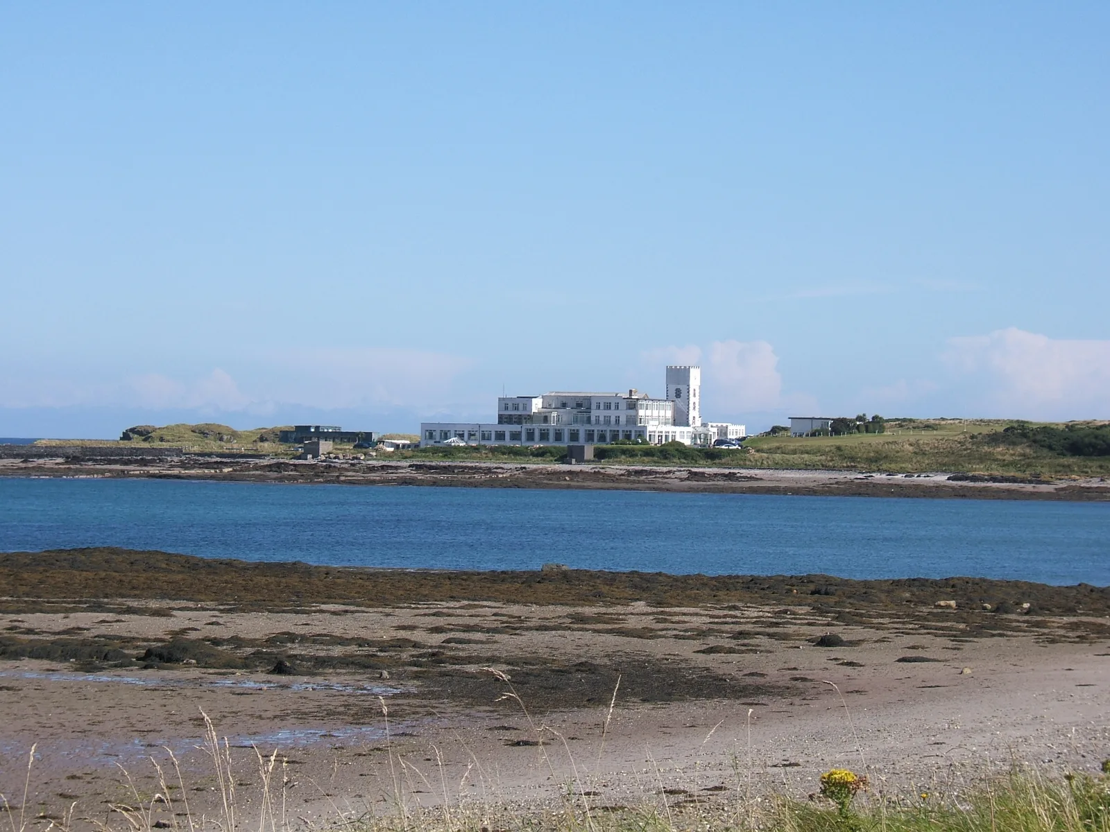 Looking across the water at Derbyhaven to the low green Langness peninsula and its golf links