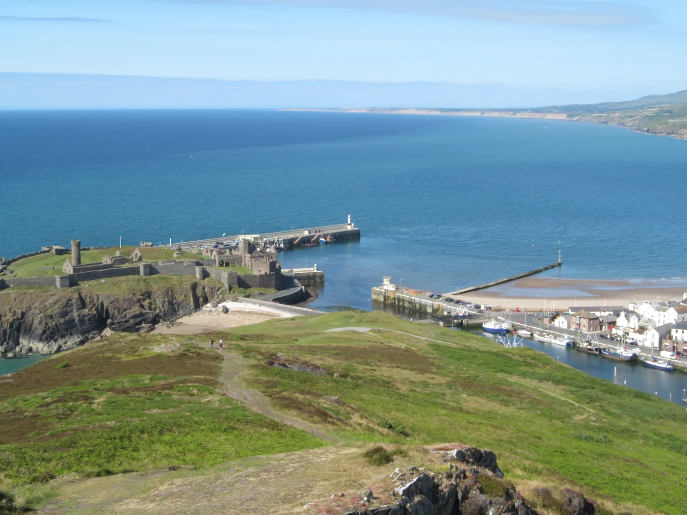 The wide sandy beach at Peel with the red sandstone walls of Peel Castle on St Patrick's Isle beyond