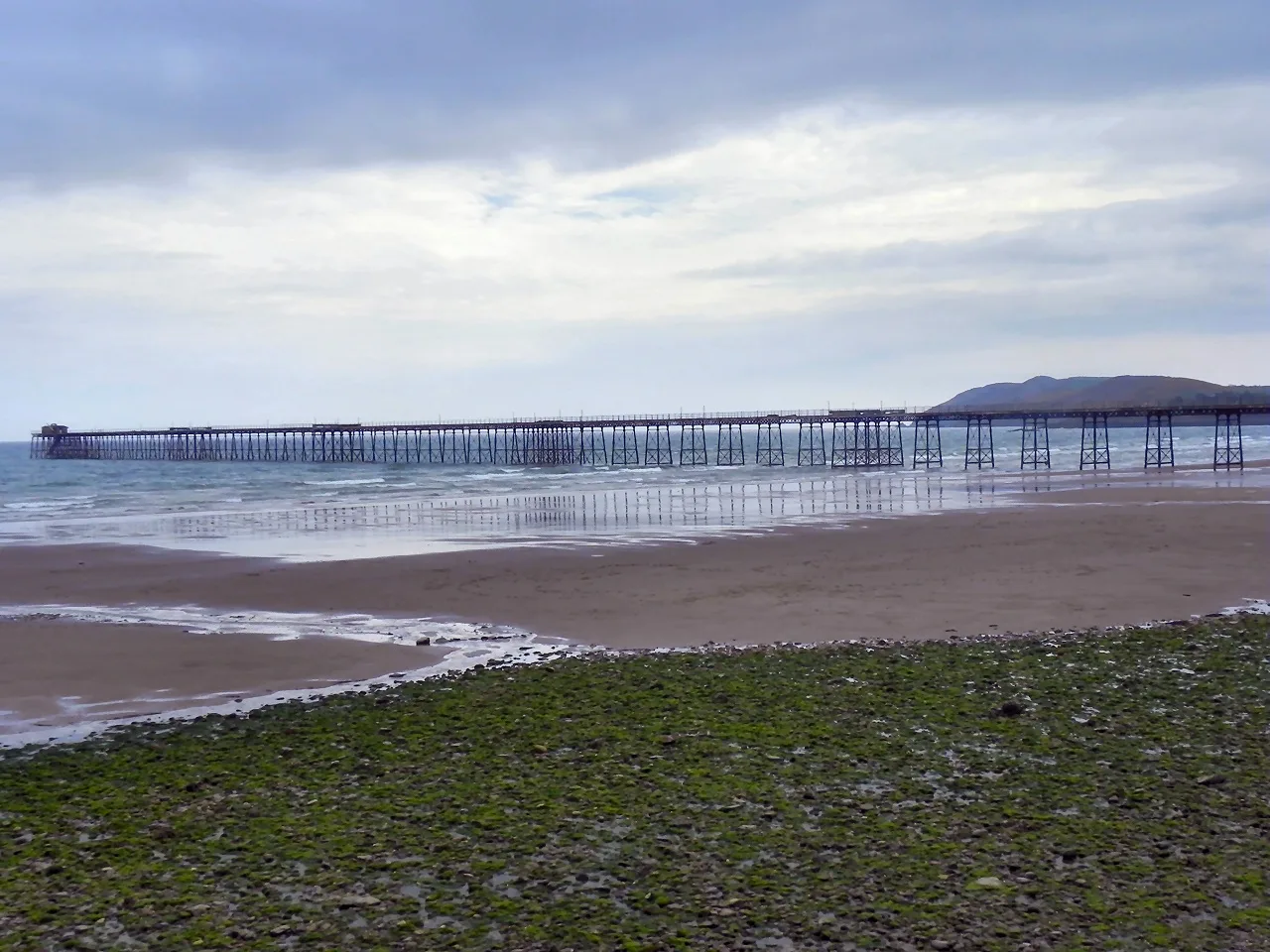 The sand at Ramsey with the long iron Queen's Pier reaching out into the bay