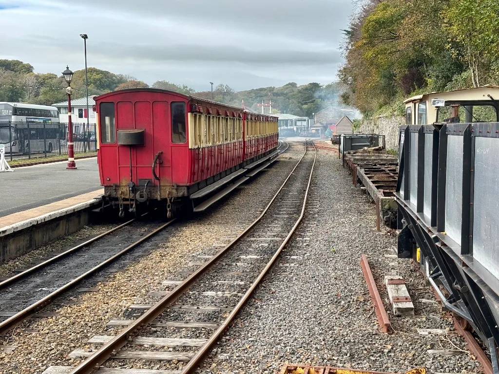 Red and cream heritage carriages standing at the platform of the Isle of Man Steam Railway station in Douglas