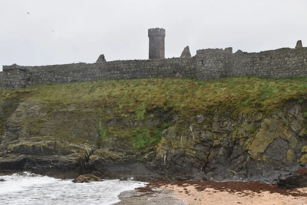 The round tower at Peel Castle, a tall narrow stone tower with battlements, standing among the ruined walls