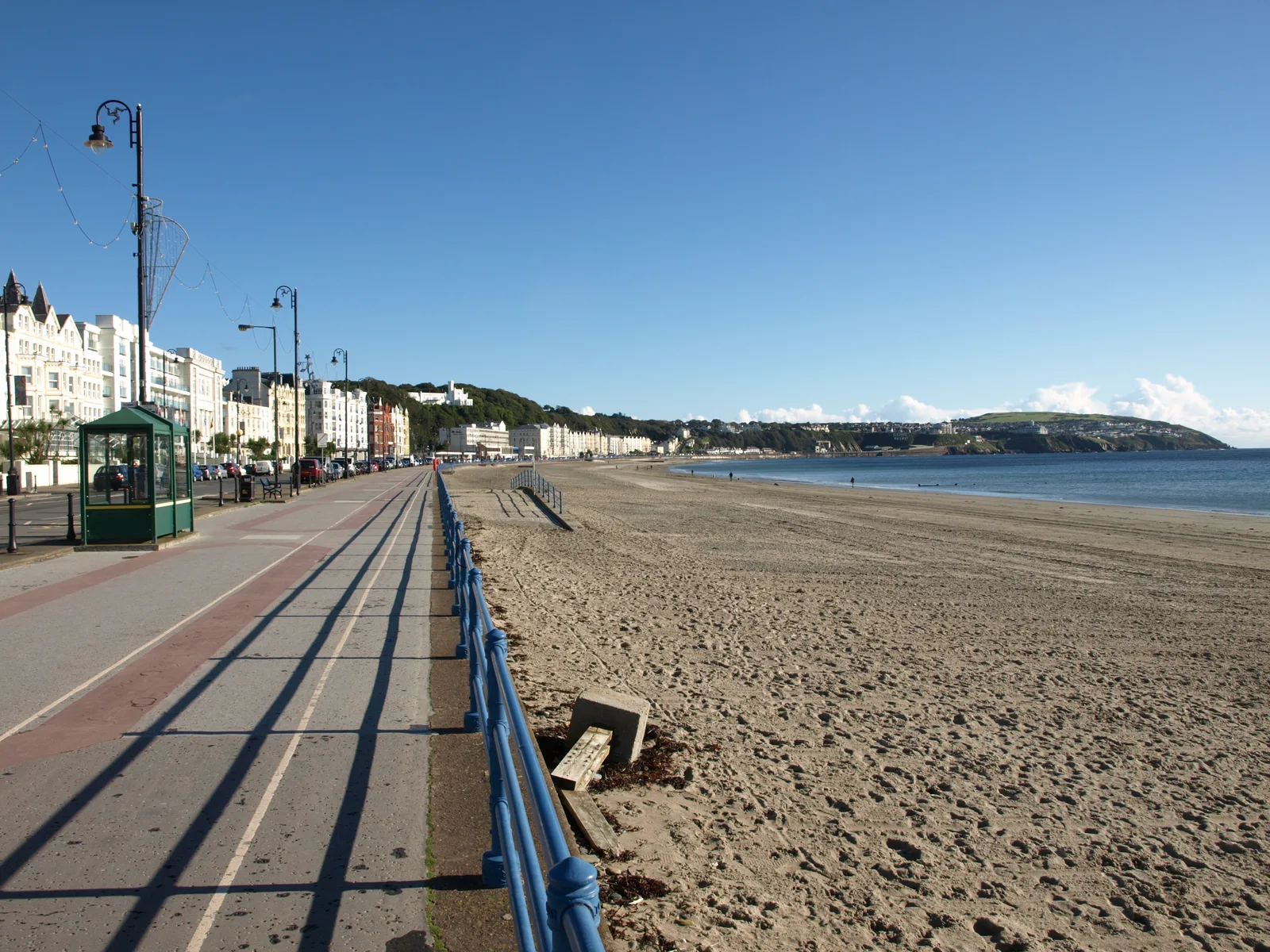 The wide sand of Douglas Beach beside the railings of the promenade