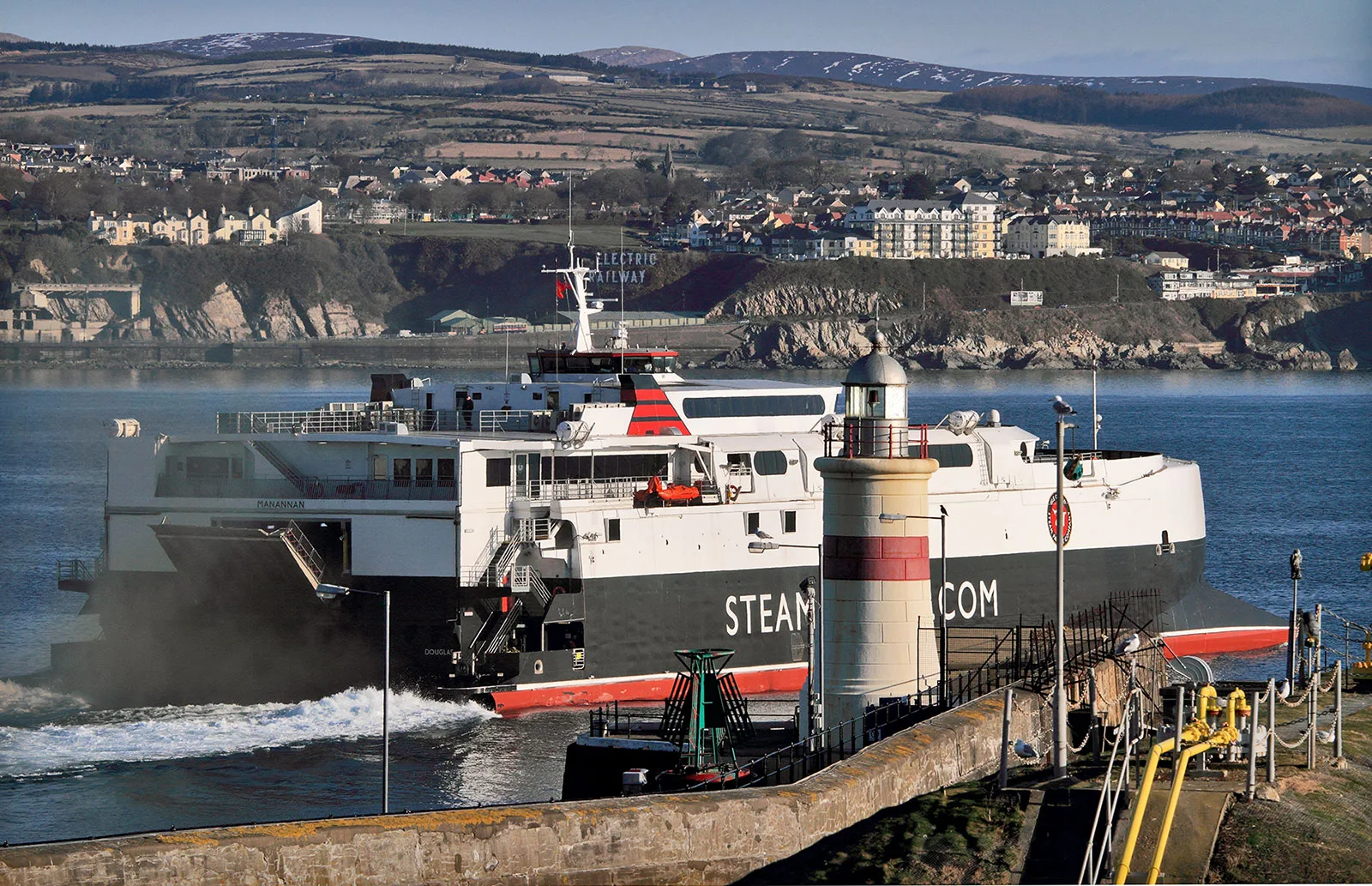 The Steam Packet fast craft Manannan passing the lighthouse at the harbour entrance in Douglas