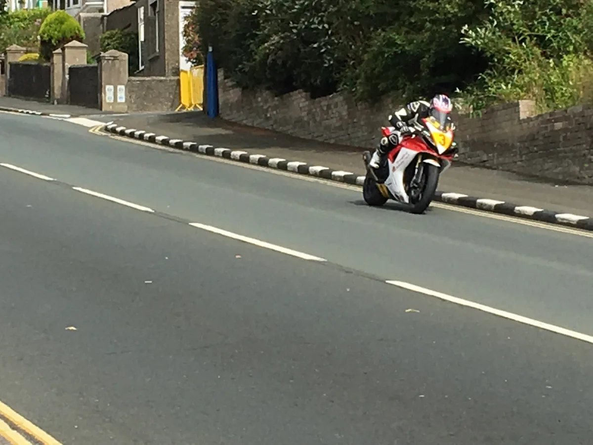 A rider racing a motorcycle at speed during the Senior Manx Grand Prix