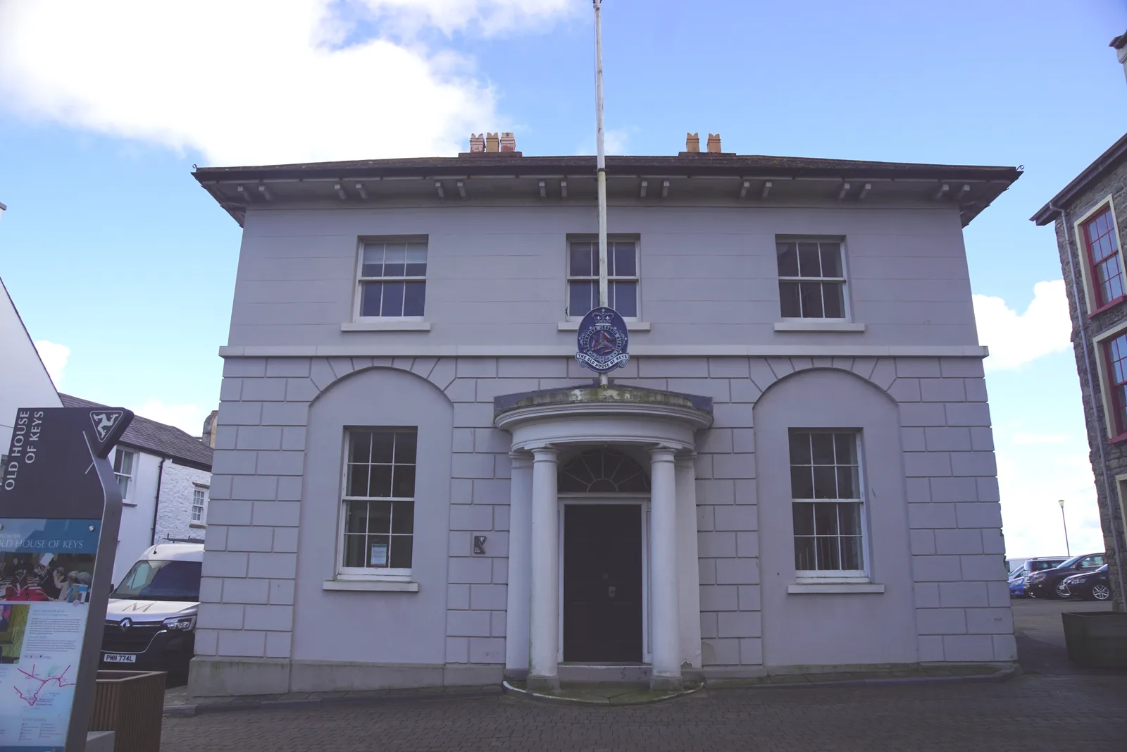 The plain two-storey rendered front of the Old House of Keys on Parliament Square, Castletown, with a columned porch