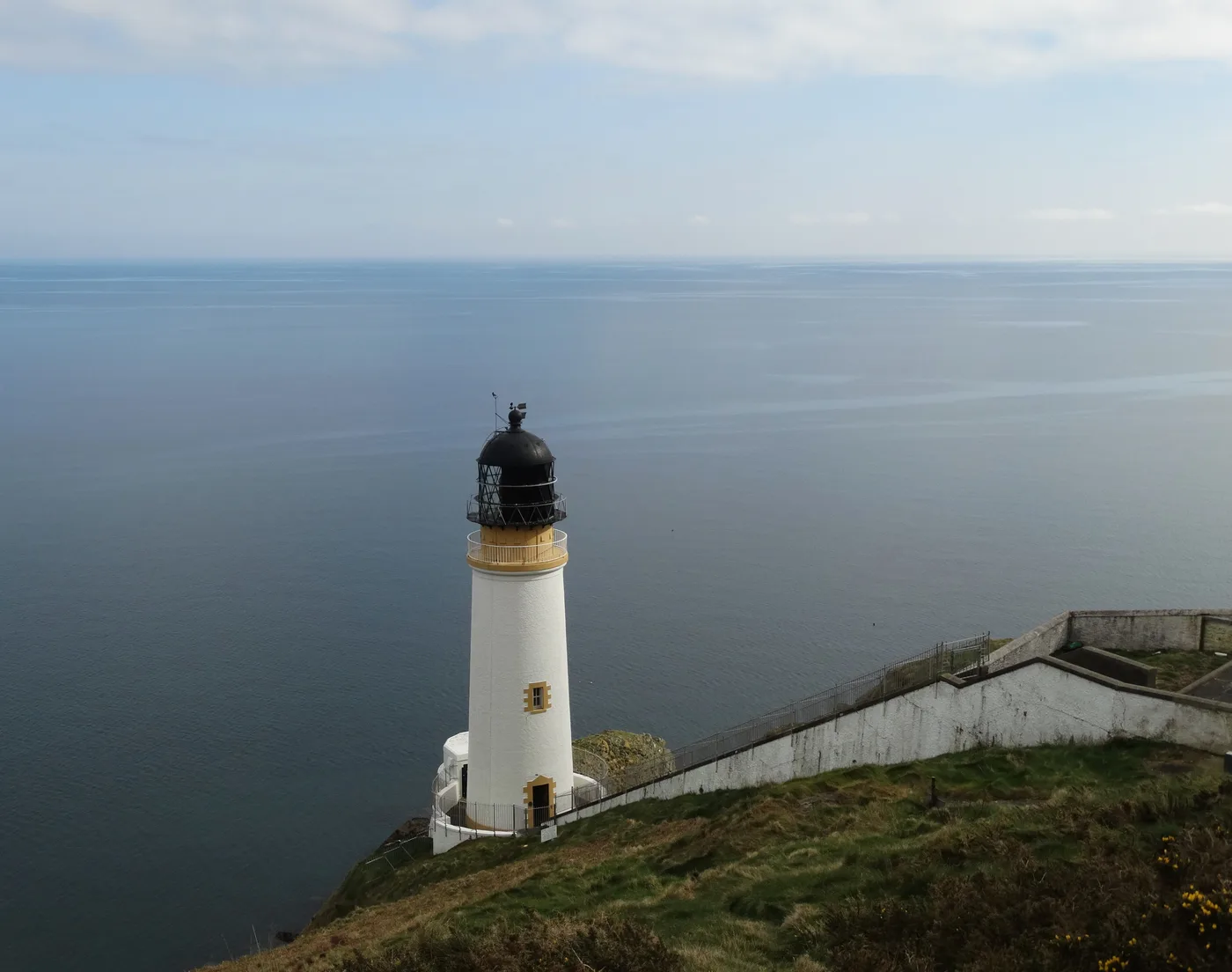 Maughold Head lighthouse set halfway down the cliff face at the eastern point of the Isle of Man