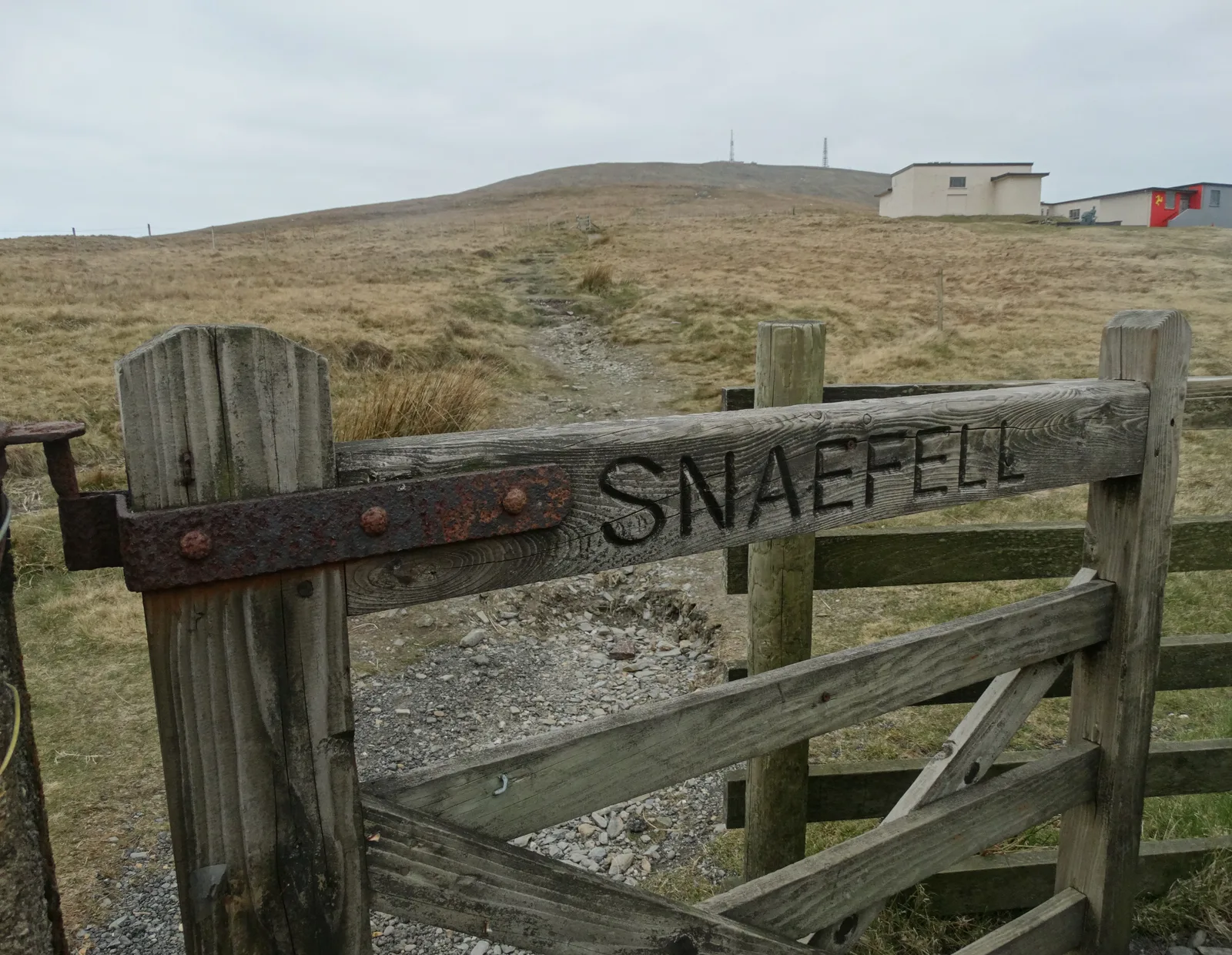 A wooden gate marked Snaefell at the start of the grassy path up the mountain from the Bungalow