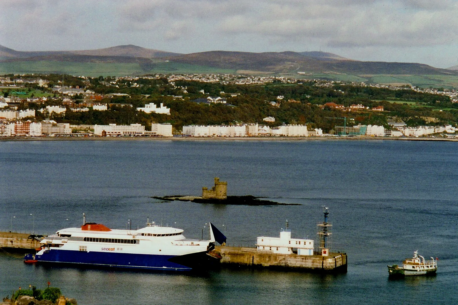 Douglas Bay seen from above the harbour, with the Tower of Refuge on its rock and the white promenade terraces lining the shore behind