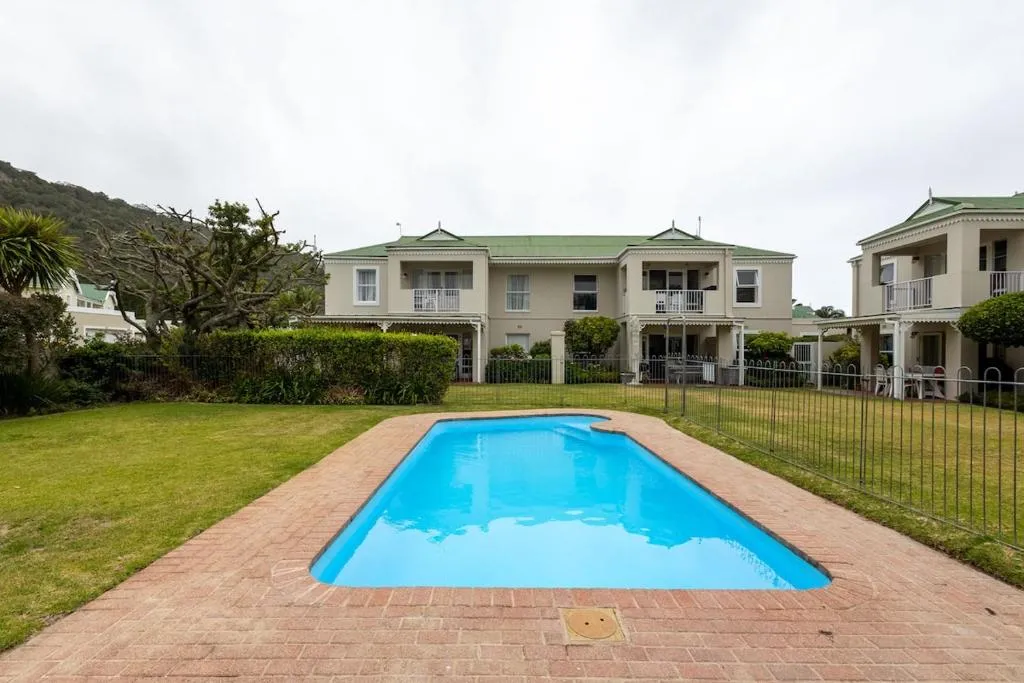 Shared complex pool fronting rows of attached units with green-roofed gables