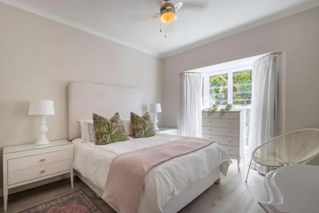 Bedroom with a bay window seating nook, chest of drawers and ceiling fan