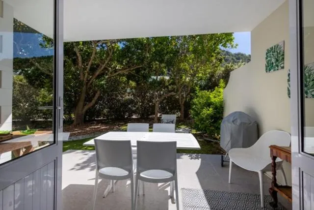 Covered patio dining area looking out over a tree-lined garden