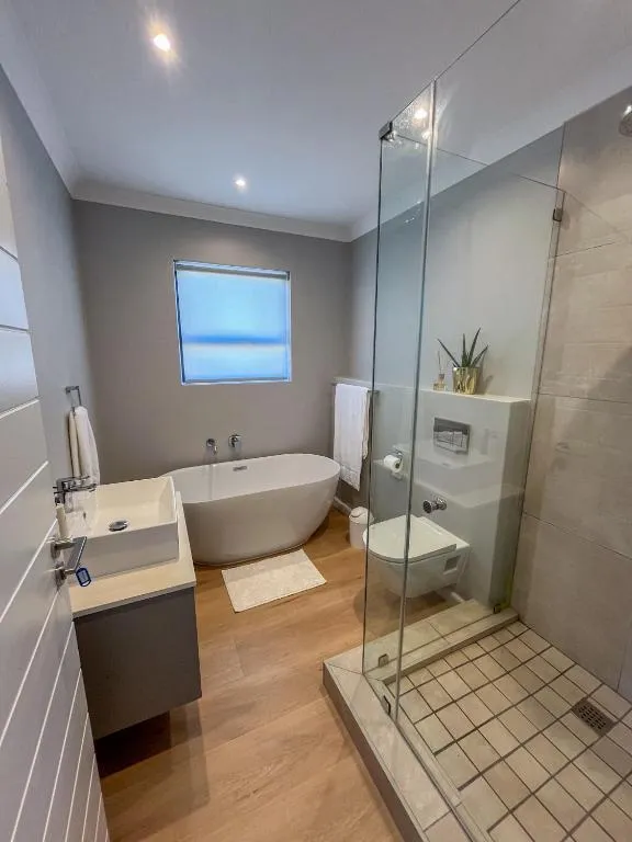 Bathroom with a freestanding tub, separate glass shower and wall-hung toilet