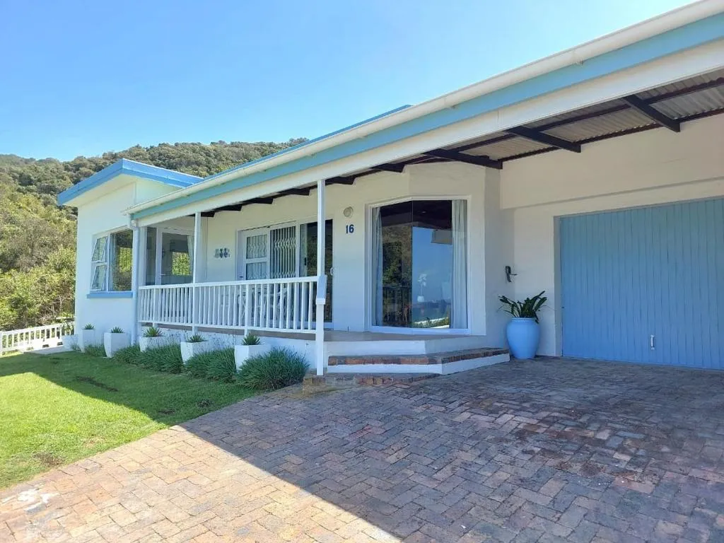 Single-storey house exterior with a blue-trimmed veranda, garage, and paved driveway
