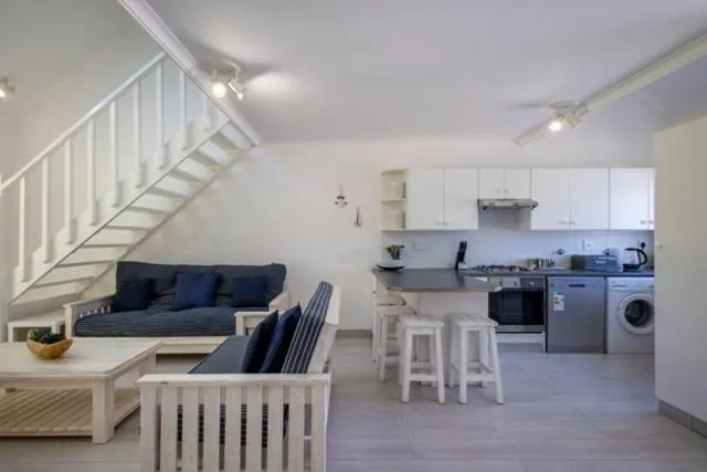 Open-plan kitchen under the staircase with a breakfast bar and washing machine