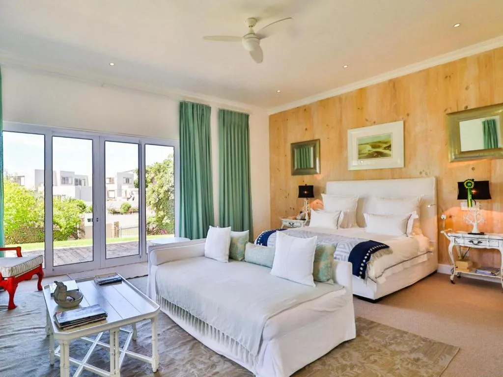 Twin daybed and queen bed in a bedroom with sliding doors opening onto a garden terrace