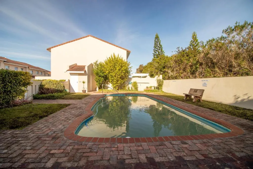 Shared complex pool in a walled brick courtyard beside the building