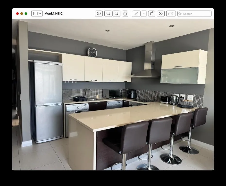 U-shaped kitchen with breakfast bar seating, built-in washing machine and fridge