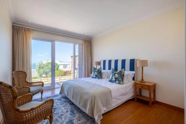 Bedroom with a striped headboard and sliding doors opening onto a sea-view balcony