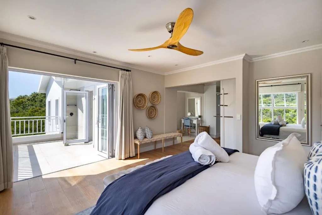 Main bedroom with a ceiling fan and folding doors onto a private balcony