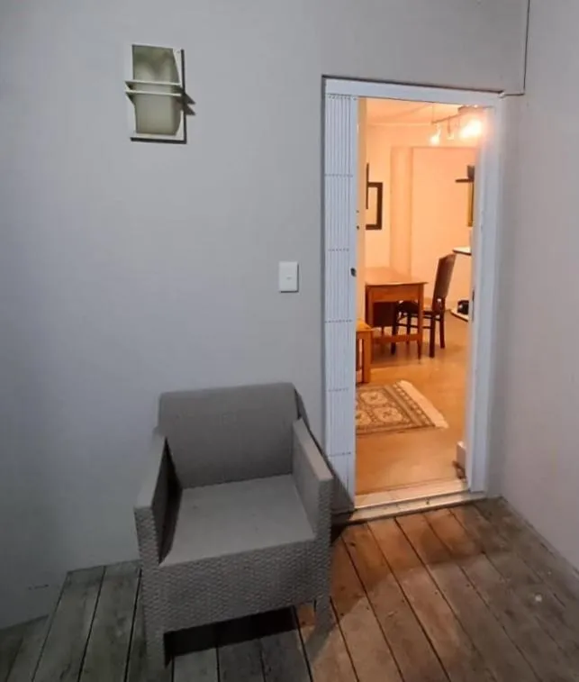 Entrance hallway with a wicker armchair opening through to the dining area beyond