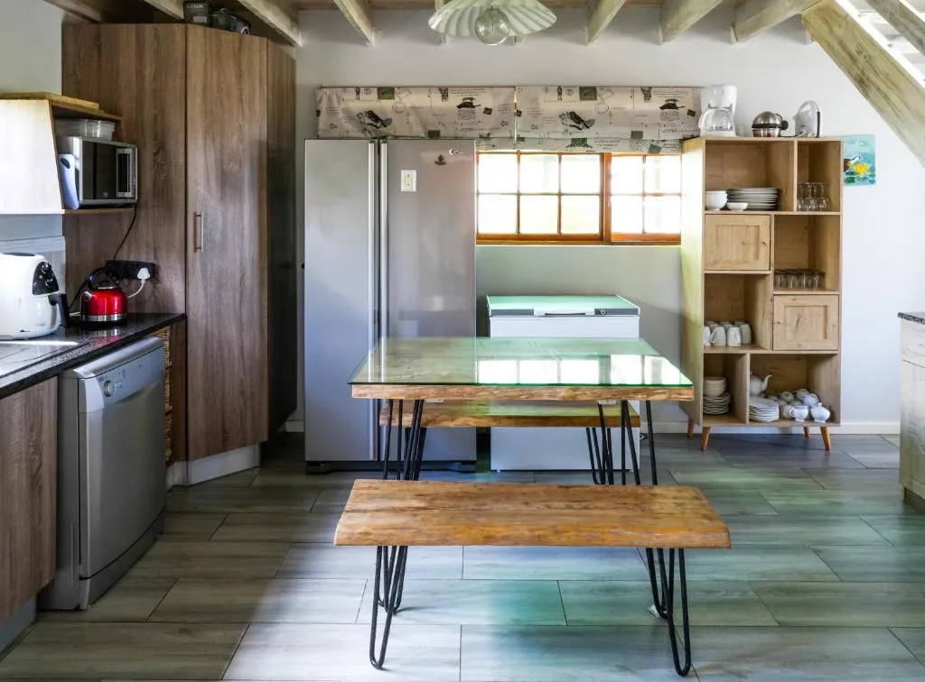 Kitchen with a fridge-freezer, dishwasher and a wooden bench-style dining table