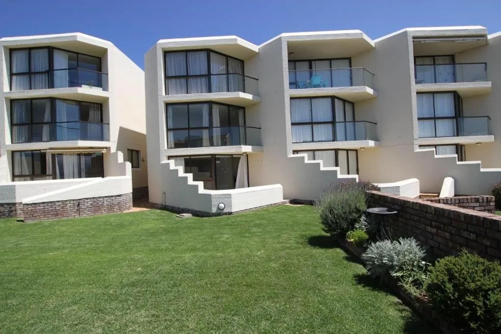 Tiered apartment block exterior with angled bay windows and private glass balconies