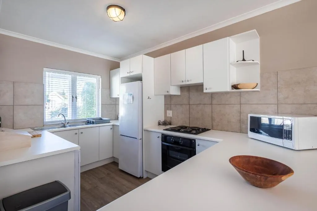 Fitted kitchen with a gas hob, oven, fridge-freezer and microwave