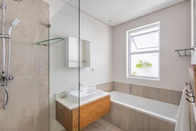 Bathroom with a walk-in shower, built-in bath and timber vanity