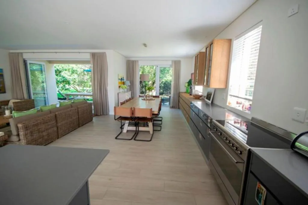 Open-plan kitchen and dining area with French doors opening onto a leafy garden