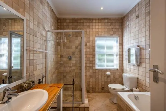 Tiled bathroom with a walk-in shower, freestanding bath, and timber vanity