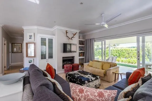 Living room with a built-in fireplace, mounted antlers, and doors open to the garden