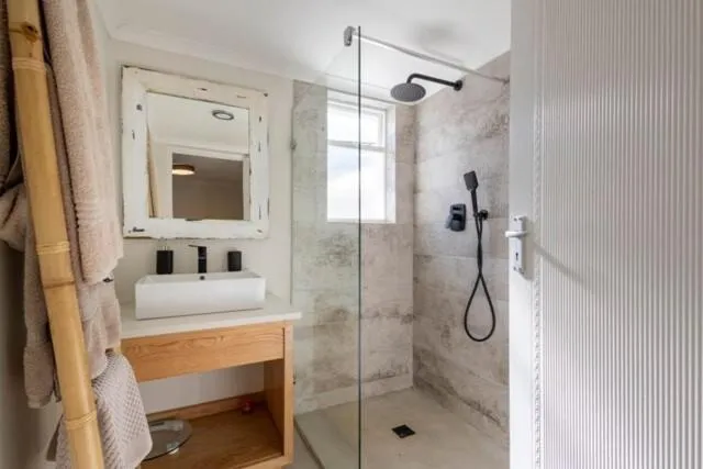 Bathroom with a walk-in glass shower, rainfall head and vessel basin on a timber vanity