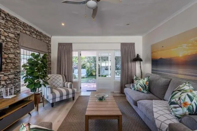 Living room with a full-height stacked-stone feature wall and a striped wingback armchair