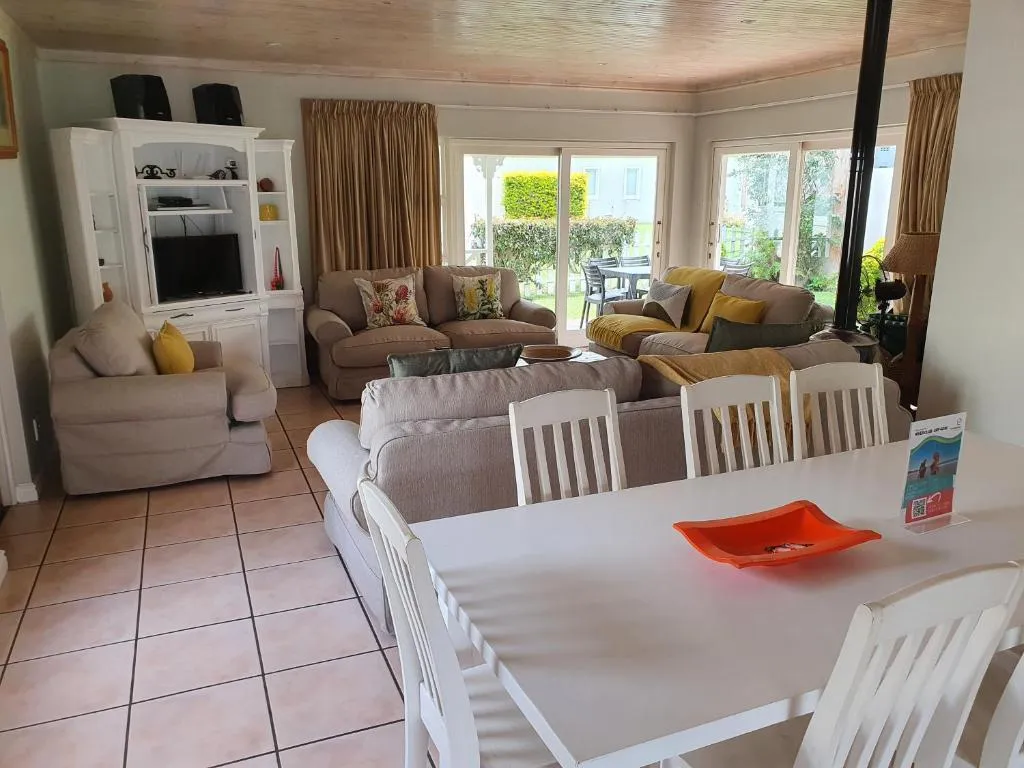 Open-plan dining table for eight beside the lounge, with sliding doors onto the garden patio