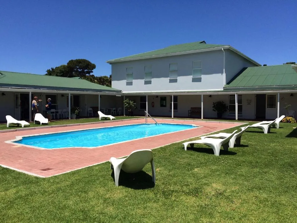 Shared estate swimming pool and loungers beside the clubhouse building on the golf estate