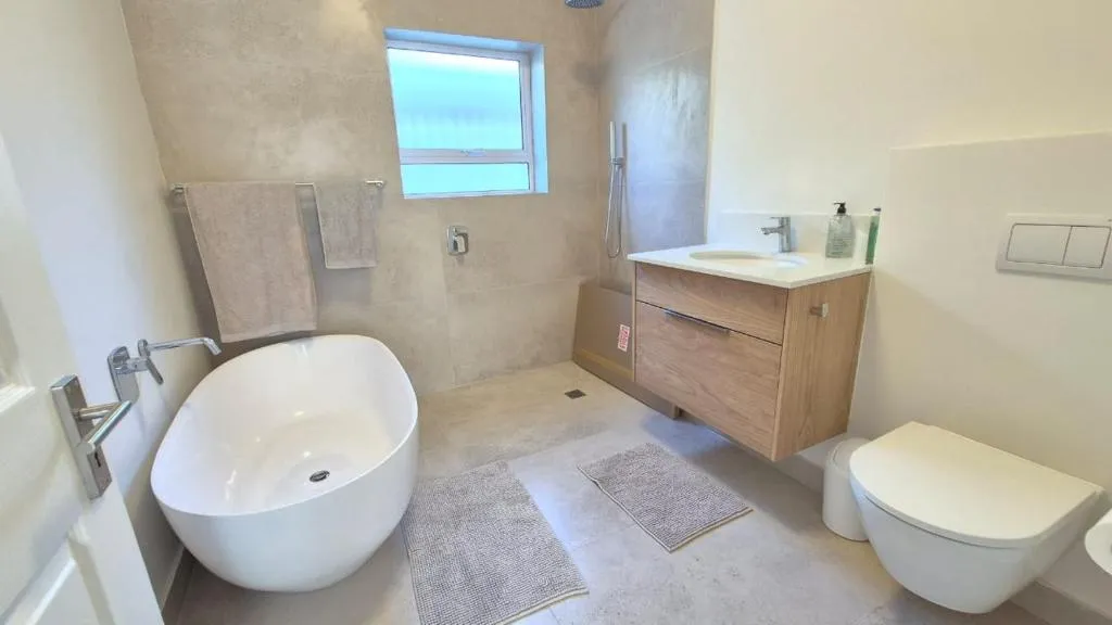 Bathroom with a freestanding tub, walk-in shower and timber vanity