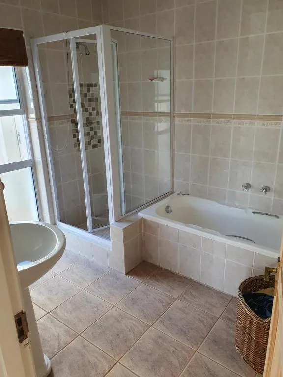 Bathroom with a separate glass shower cubicle and a built-in bathtub