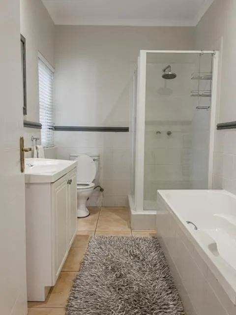 Bathroom with a corner shower, built-in bath, toilet and vanity basin