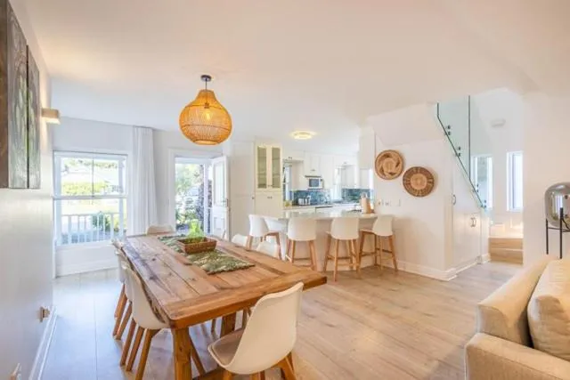 Open-plan dining and kitchen area with a wooden table and a galleried staircase