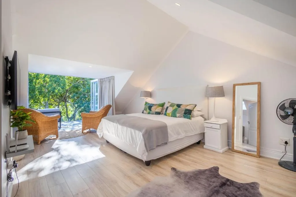 Loft bedroom with vaulted ceilings and French doors onto a treed balcony